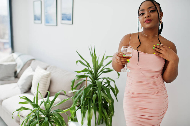 Fashionable photo of young beautiful romantic african american woman with glass of wine, wearing pink dress. Summer, spring style. - Foto, Imagem