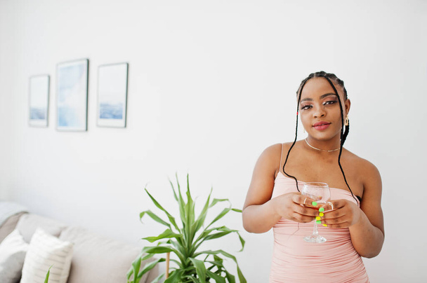 Fashionable photo of young beautiful romantic african american woman with glass of wine, wearing pink dress. Summer, spring style. - Foto, immagini