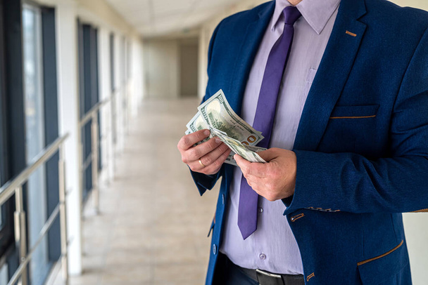 hombre de negocios feliz sosteniendo un montón de dólares después del acuerdo de éxito. concepto de financiación - Foto, imagen