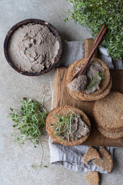 Homemade meat or chicken liver pate with multigrain crackers and microgreen. Top view. - Valokuva, kuva