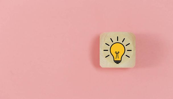 Light bulb creative idea icon on wooden cube block pink background. inspiration education symbol, creative idea concept. - Foto, Imagem