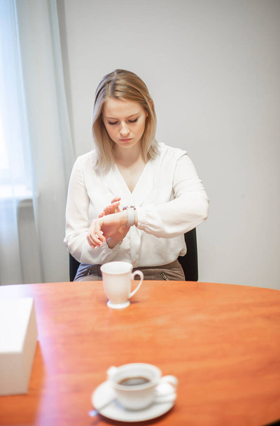 Kancelářský portrét krásné mladé obchodní žena při pohledu na její hodinky v kanceláři - Fotografie, Obrázek