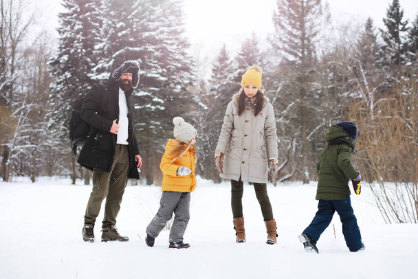 雪の中で冬の屋外で遊んで笑って幸せな家族。シティパーク冬の日. - 写真・画像