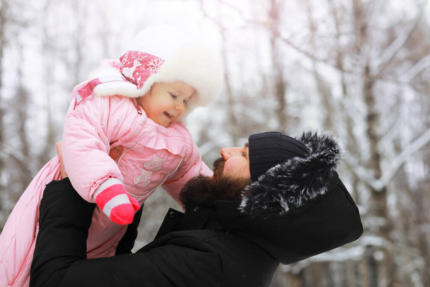 Happy family playing and laughing in winter outdoors in snow. City park winter day. - 写真・画像
