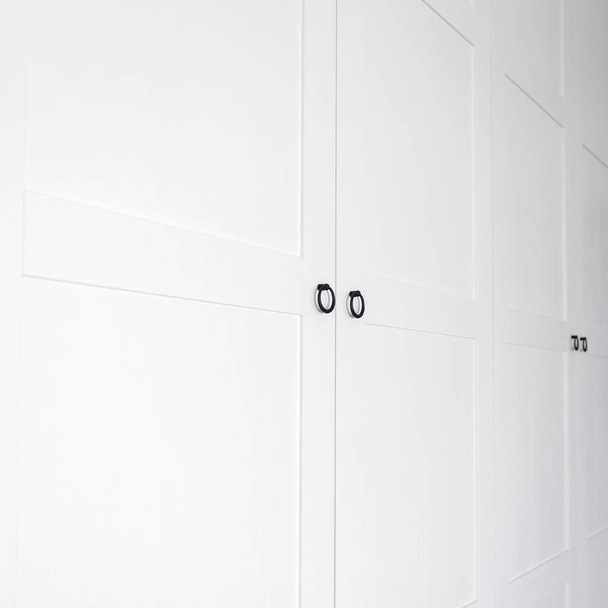 Biała szafa vintage z listwami koronowymi drewniane półki i szuflady i otwarte drzwi fasady w jasnym pustym pomieszczeniu - Zdjęcie, obraz