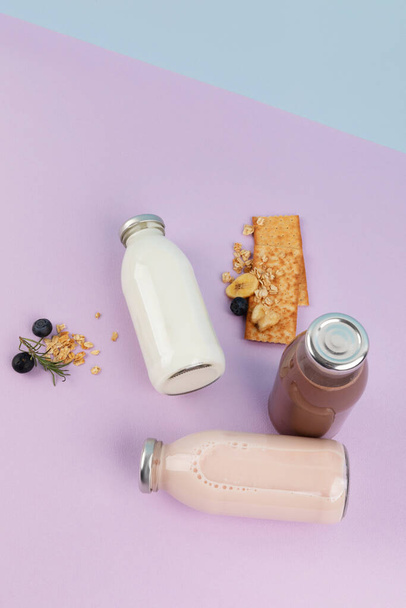 white milk, strawberry milk, chocolate milk in a sky blue and purple background - Valokuva, kuva