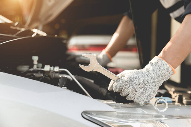 Mécanicien automobile réparateur mains réparation d'un moteur de voiture atelier automobile avec une clé, service de voiture et d'entretien, Service de réparation. - Photo, image