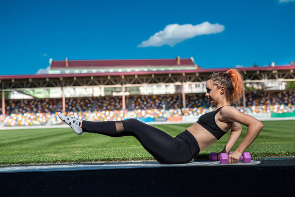 Spor giyim bayan antrenörü Green Stadyumu 'nda spor yapıyor. sağlıklı sportif yaşam tarzı - Fotoğraf, Görsel