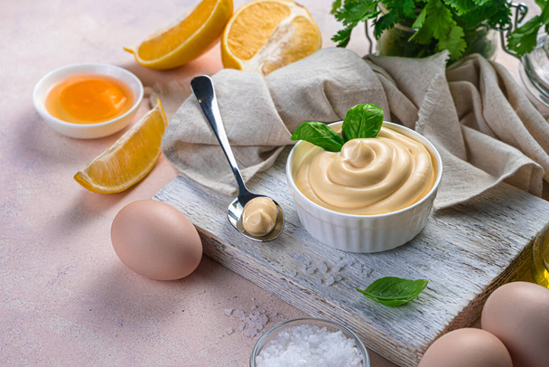 Mayonnaise and natural ingredients on a light background. Side view, copy space. - Photo, Image
