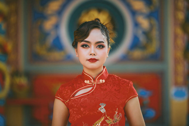 Piękny azjatycki chiński kobieta noszenie Cheongsam tradycyjny czerwony strój mody posting chiński księżycowy Nowy Rok. - Zdjęcie, obraz