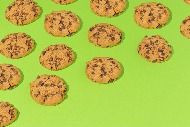 Composição com biscoitos de chocolate contra um fundo verde claro. Conceito festivo ou alimentar. - Foto, Imagem