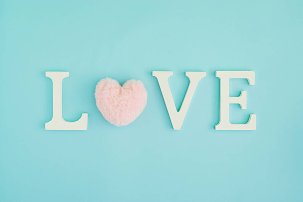 Palabra de amor hecha con corazón rosa y letras decorativas de madera. Día de San Valentín concepto creativo fondo. Puesta plana. - Foto, Imagen