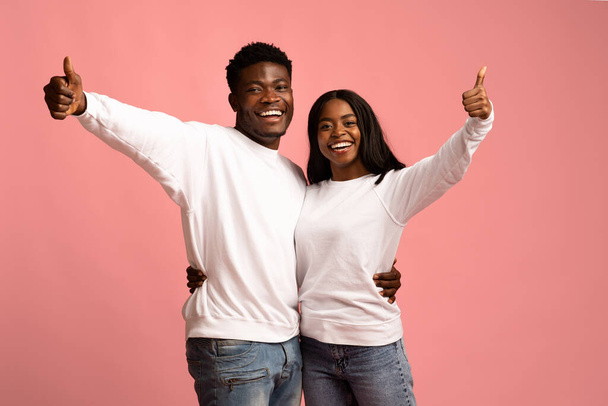 Boldog afro-amerikai szerelmeseinek ölelését rózsaszín stúdió háttér - Fotó, kép