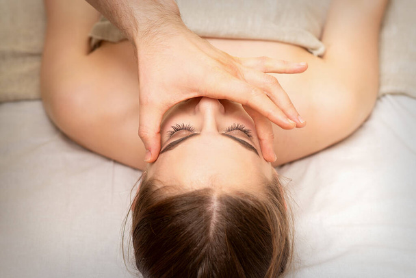 Massaggio di faccia con le dita di un massaggiatore. Cura della pelle del viso femminile in un salone di bellezza termale - Foto, immagini