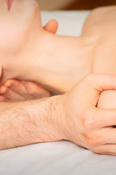 Чоловічий масаж плече молодої жінки лежить на масажному столі в спа-центрі
 - Фото, зображення