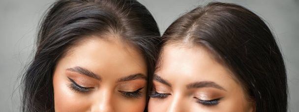 Πορτρέτο νέων όμορφων δύο γυναικών με μακριές βλεφαρίδες και κλειστά μάτια μετά από επεκτάσεις βλεφαρίδων - Φωτογραφία, εικόνα