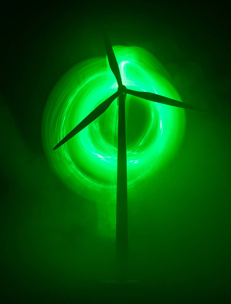 自然エネルギーやクリーンエネルギーの概念における電力。風力タービンは夜間に丘の上で代替エネルギーを生産する。ミニチュアの小さな創造的な装飾。選択的焦点 - 写真・画像
