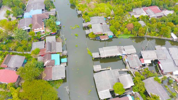 Aerial top view of residential local houses with Phasi Charoen, Chao Phraya canal or river, nature trees, Nonthaburi City, Ταϊλάνδη σε αστική πόλη της Ασίας, κτίρια. - Φωτογραφία, εικόνα