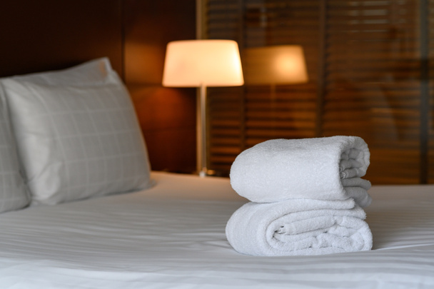 Puhdas valkoinen pyyhe asetettu sängylle hotellihuoneessa, rentoutua, loma, loma käsite - Valokuva, kuva