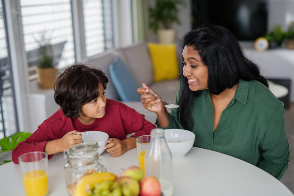 Little boy having breakfast with his mother at home. - Valokuva, kuva