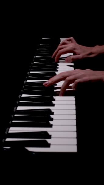 A női zongorista kezek klasszikus zenét játszanak egy gyönyörű zongora közeli felvételen. A zongorakulcsok sötét színekben záródnak. A tanuló zongorázni tanul. Zeneiskola. Filharmonikusok. - Felvétel, videó