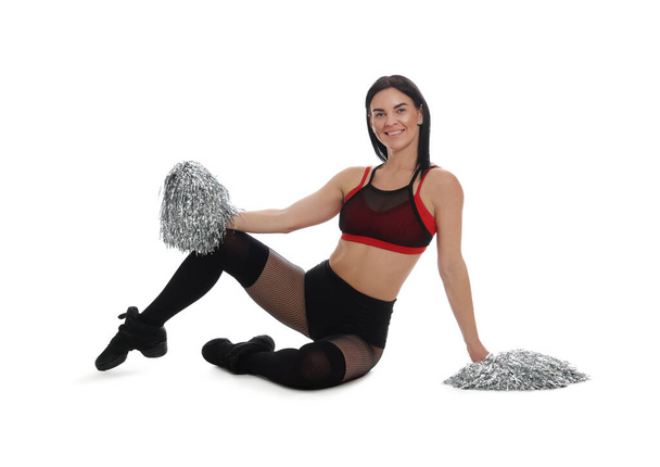Beautiful cheerleader in costume holding pom poms on white background - Фото, изображение