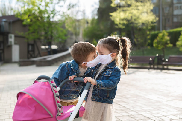 Children kiss in protective face masks. Coronavirus, covid-19. - Valokuva, kuva