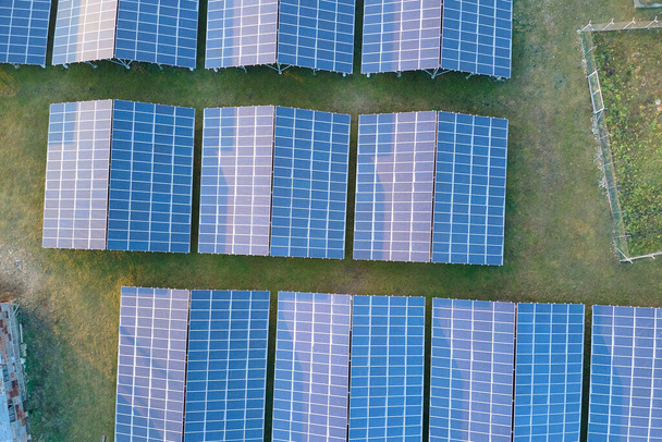 Aerial view of large sustainable electrical power plant with rows of solar photovoltaic panels for producing clean ecological electric energy. Renewable electricity with zero emission concept. - Photo, image