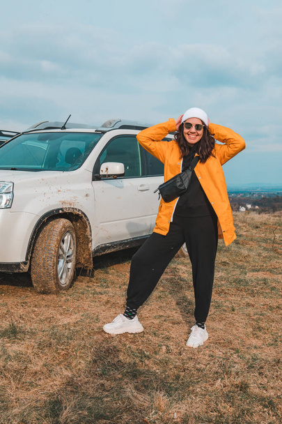 young stylish woman portrait in front of off road suv car resting outdoors - Photo, Image