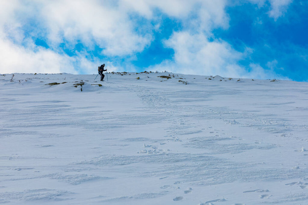 Lidé sestupují na horu a vytvářejí novou horskou stezku plnou čerstvého sněhu. - Fotografie, Obrázek