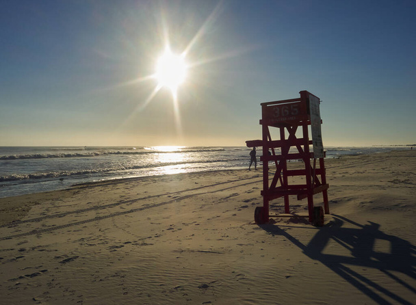 Vroeg in de ochtend kwam de zon op en waren er een paar golven in de oceaan. Eén persoon genoot van dit magische moment. Florida, 25 januari 2016. - Foto, afbeelding