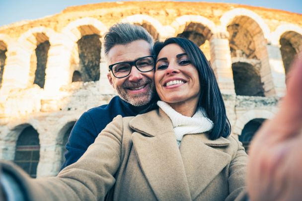 Pareja feliz de turista senior divirtiéndose tomando una selfie frente al famoso monumento de Italia - Vacaciones, turismo y concepto de viaje - Foto, imagen