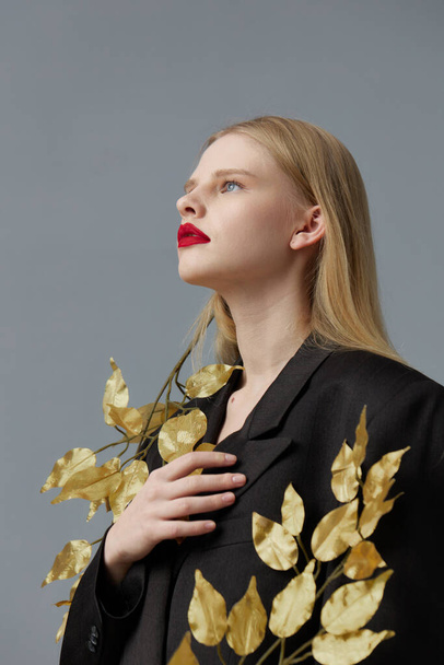 fashionable woman decorations black jacket golden leaves studio model unaltered - Φωτογραφία, εικόνα
