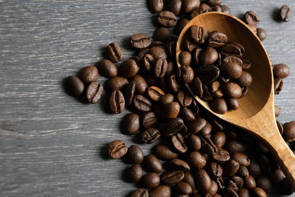roasted coffee beans with wooden spoon on a wooden background - Photo, Image