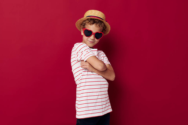 boy wearing sunglasses wearing a hat posing childish style - 写真・画像