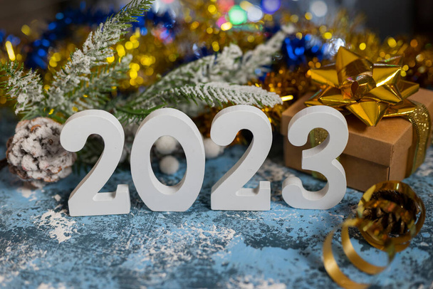 クリスマスツリーの枝とギフト包装で新年のお祝いのための白い数字2023 - 写真・画像