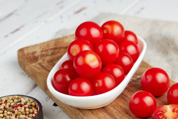 Tomates cherry rojos frescos sobre fondo de madera blanco - Foto, Imagen