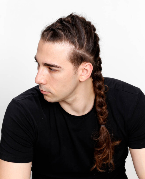 Stylish male model with braids posing in studio on isolated background. Style, hairstyle, fashion concept. - Zdjęcie, obraz