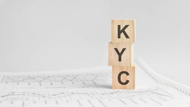 KYC - letters on wooden cubes. concept on cubes and diagrams on a green background. Business as usual concept image. space for text in left. front view. KYC - short for know your customer our client - Foto, Bild