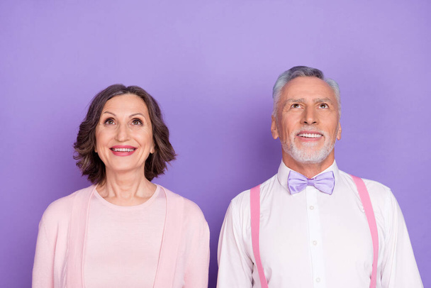 Photo of cheerful excited partners look interested up empty space isolated on violet color background - Fotografie, Obrázek