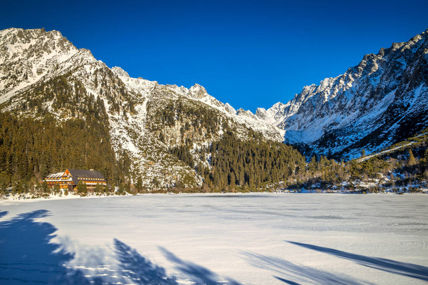 Paisaje de montaña con tarn congelado en temporada de invierno. El lago Popradske pleso en el Parque Nacional High Tatras, Eslovaquia, Europa. - Foto, imagen
