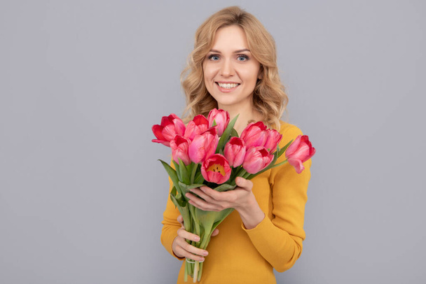 щаслива жінка з тюльпанами. пані тримає квіти для весняного відпочинку. щаслива дівчина з букетом
 - Фото, зображення