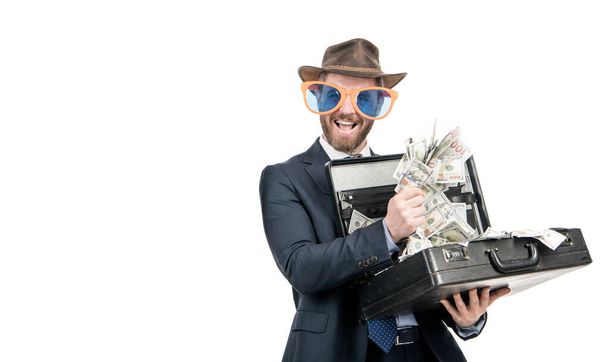 Деньги делают человека. Счастливый шоумен держит чемодан с деньгами. Богатый бизнесмен. Джекпот - Фото, изображение
