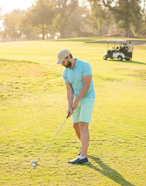 mannelijke golfspeler op professionele golfbaan. golfer in cap met golfclub. mensen levensstijl. - Foto, afbeelding