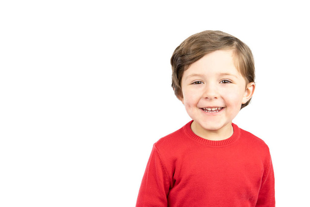 Cheerful laughing child in red sweater. Studio shot on white background. - Zdjęcie, obraz