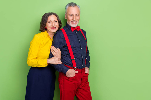 Photo of two positive peaceful persons lady hold man hand enjoy free time together isolated on green color background - Foto, Bild