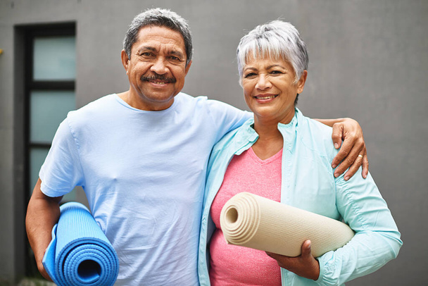 Mets-toi en forme. Portrait d'un couple âgé heureux portant leurs tapis d'exercice à l'extérieur. - Photo, image