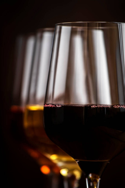 Vin rouge, blanc et rose dans des verres sur fond bois et collection de bouteilles de vin, espace de copie - Photo, image