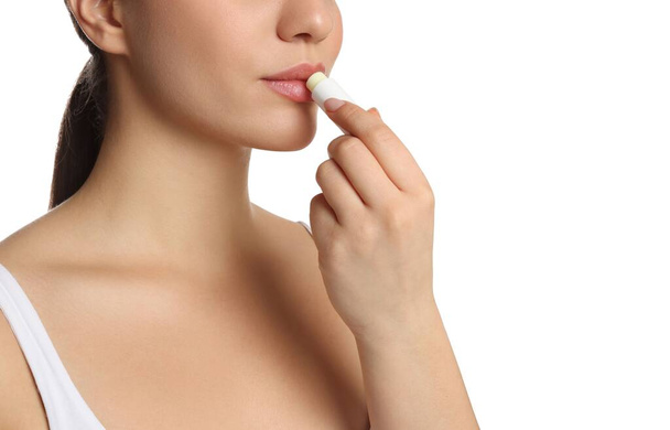 Young woman applying lip balm on white background, closeup - Foto, immagini