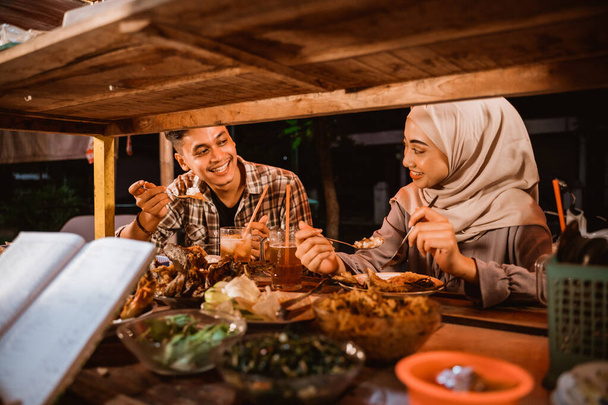 muslim couple enjoy having iftar dinner at traditional food stall - Zdjęcie, obraz